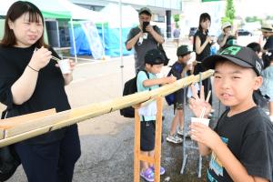 流しそうめんを楽しんでいる親子