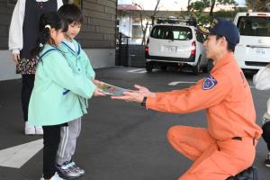 消防隊員からカレンダーを受け取る園児たち