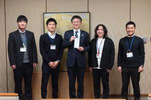 市の地域おこし協力隊と職員有志が公有地活用の実証実験で得た収益金を寄附した時の様子