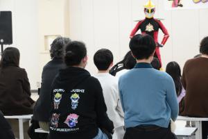 ヒーローショーで、ミツケンバーパーカーを着ている観客