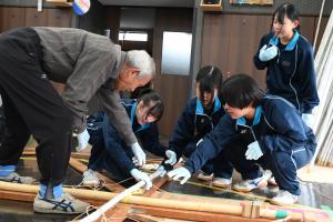 協会の人から指導を受けている高校生たち