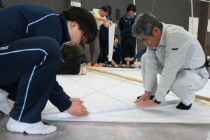 協力して和紙の貼り付けを行う様子