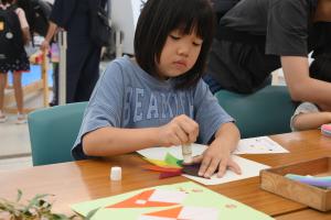 アートワークショップで七夕の飾り付けを作っている子ども