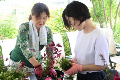 ケイ山田先生が月ヶ岡特別支援学校見附分校生徒に寄せ植えを指導している様子