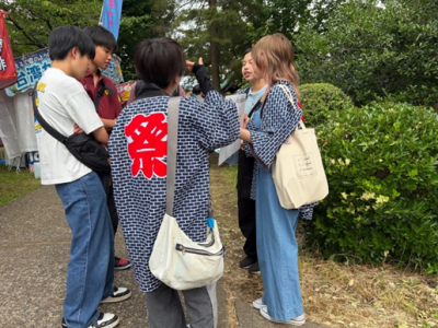凧合戦で今町商店街まちあるきマルシェに関するアンケートを実施する学生の様子