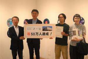 来館者50万人目になった桜井さん家族と記念撮影