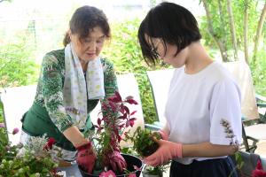 ケイ山田先生が月ヶ岡特別支援学校見附分校生徒に寄せ植えを指導している様子