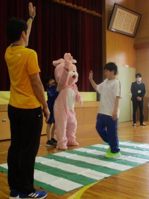 うさっぴーと一緒に手を挙げて横断歩道を渡る児童