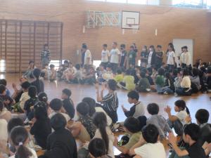 全校児童が6年生に向けて拍手を送る様子